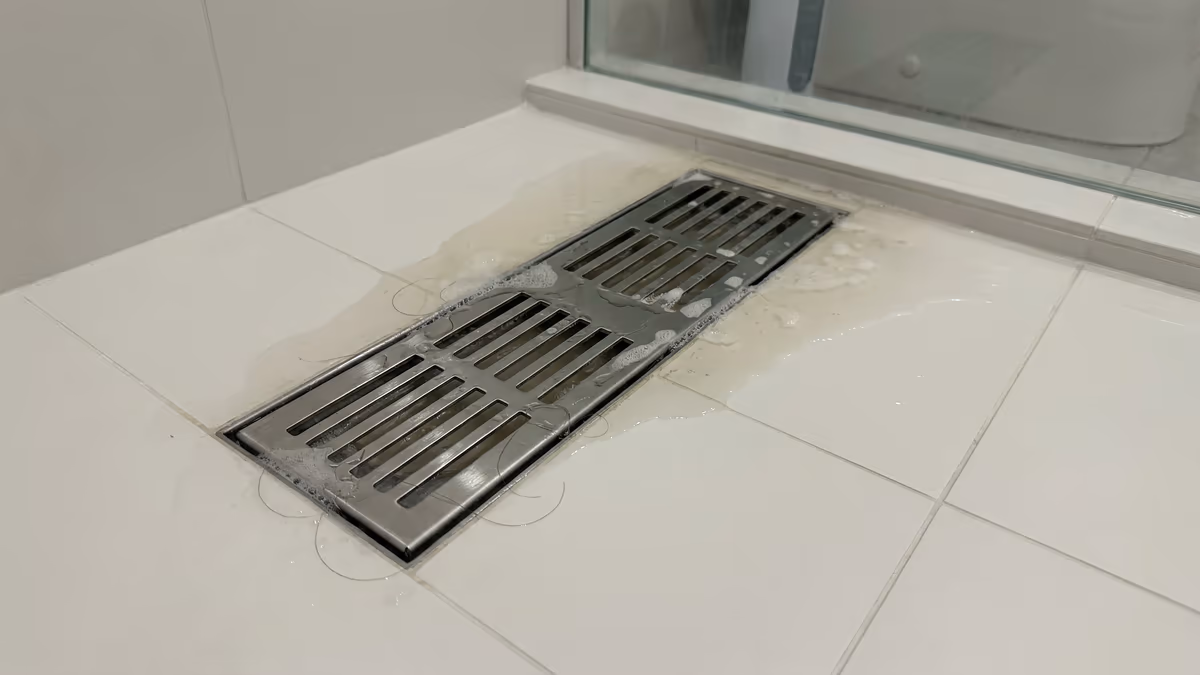 Ralo do box do banheiro com água acumulada