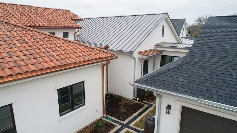 Diferentes tipos de telhados com sistemas de calhas e drenagem